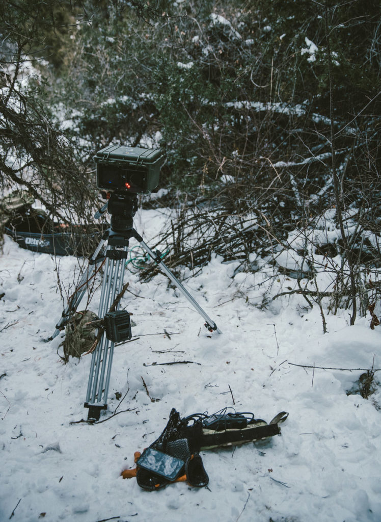 a camera trap on a tripod in the snow